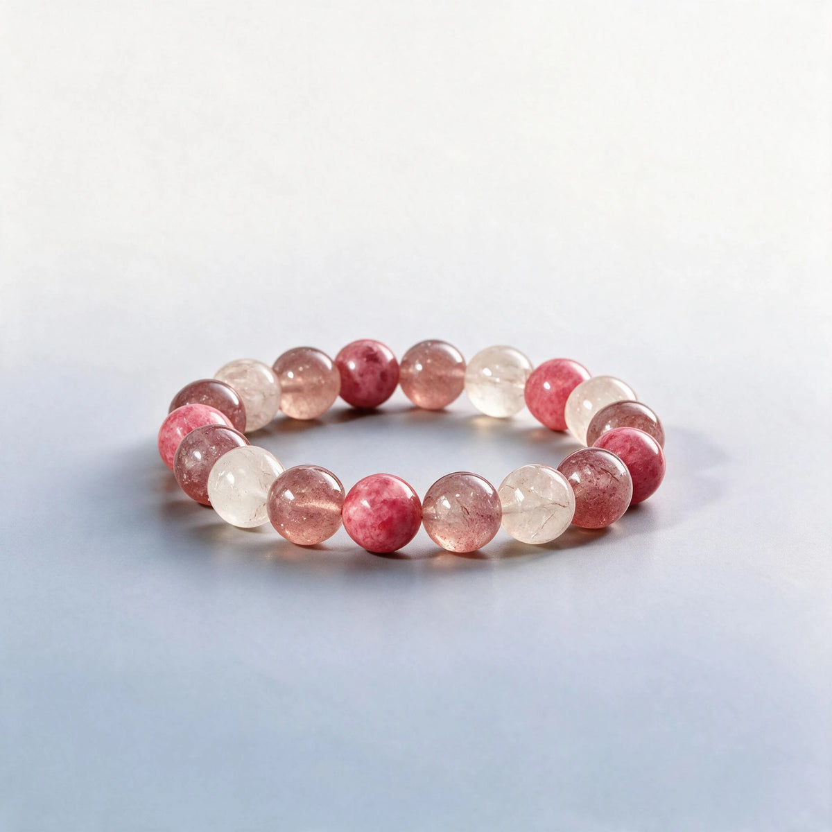 Handcrafted Heart Chakra bracelet featuring natural rhodonite, strawberry quartz, and rutilated quartz by Ember Quiet.
