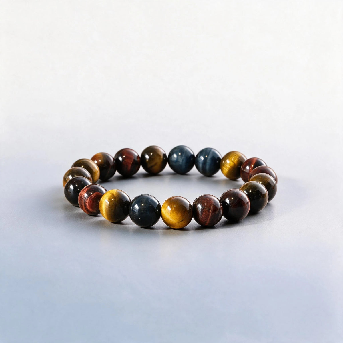 Handcrafted Triple Tiger's Eye chakra bracelet featuring natural golden, blue, and red tiger's eye by Ember Quiet.