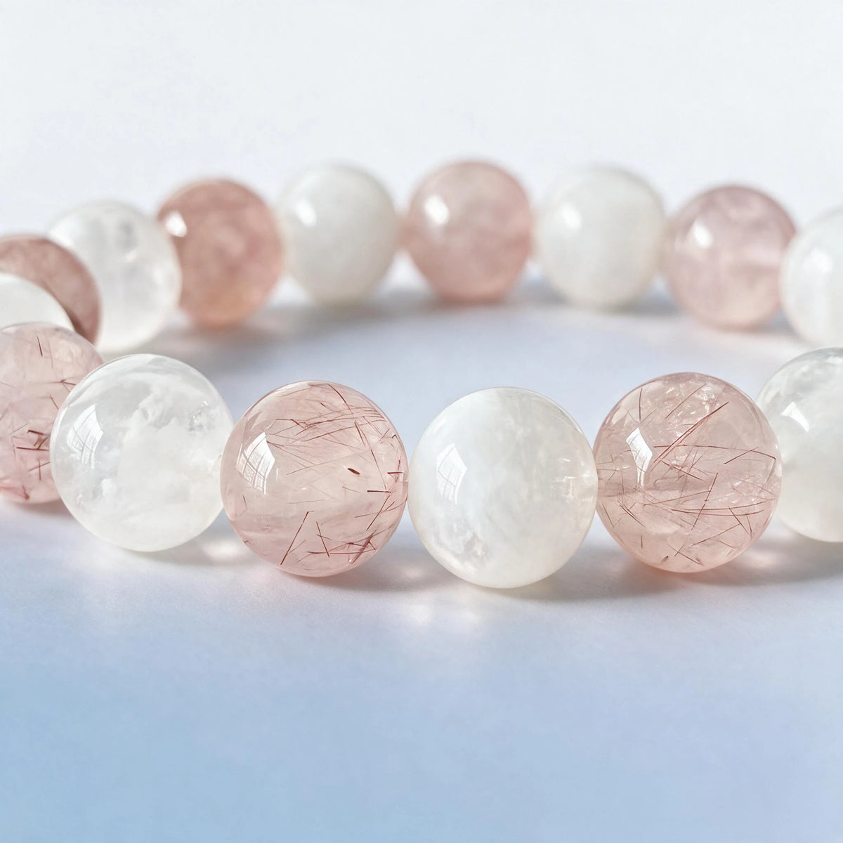 Macro close-up of authentic natural pink rutilated quartz needles and glowing white moonstone by Ember Quiet.