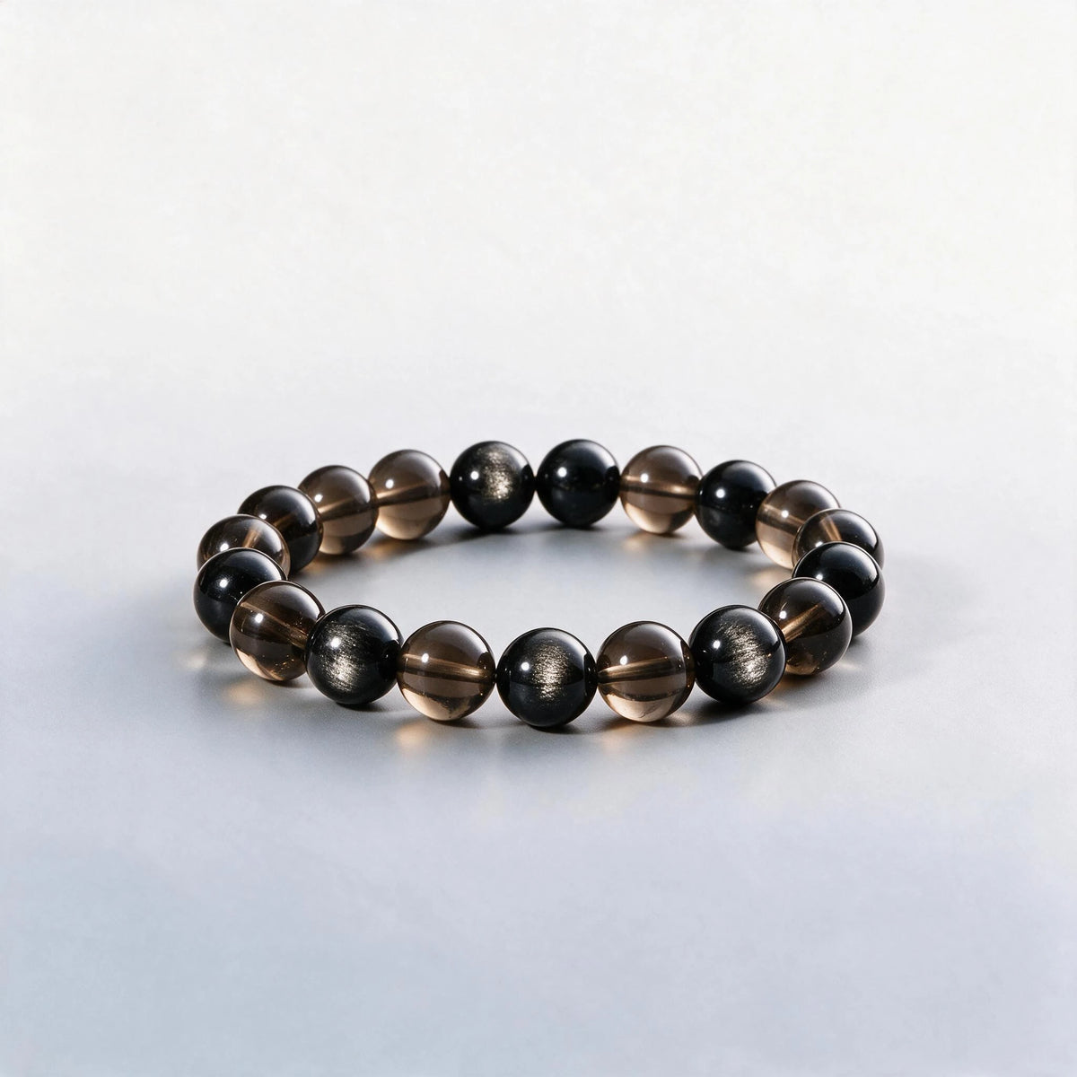 Handcrafted Root & Third Eye Chakra bracelet featuring silver sheen obsidian and smoky quartz by Ember Quiet.