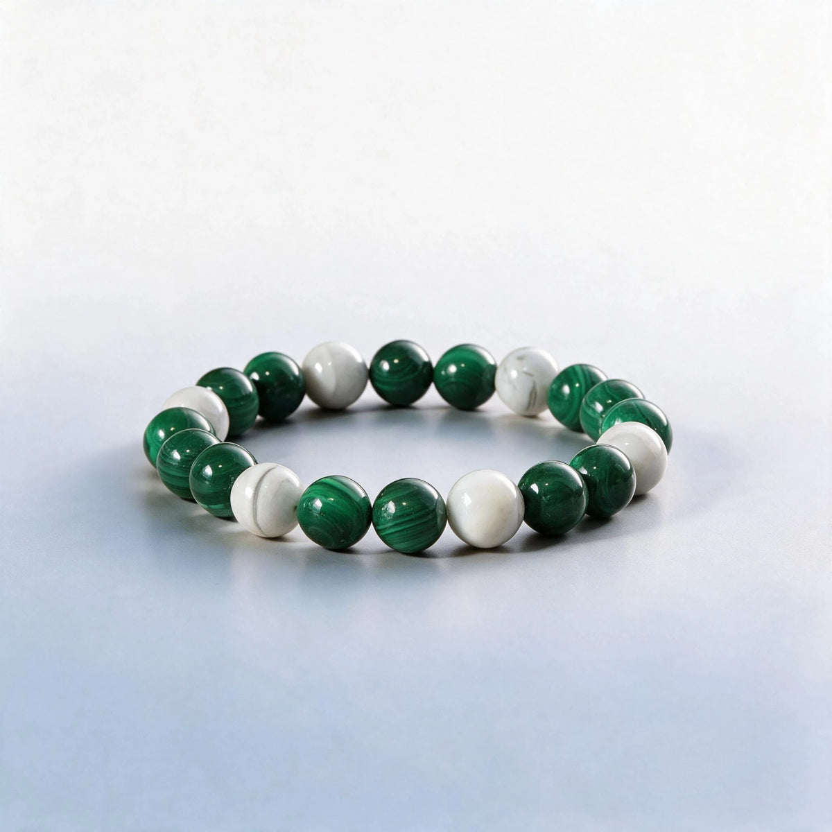 Handcrafted Heart Chakra bracelet featuring banded green malachite and misty cloud agate by Ember Quiet.