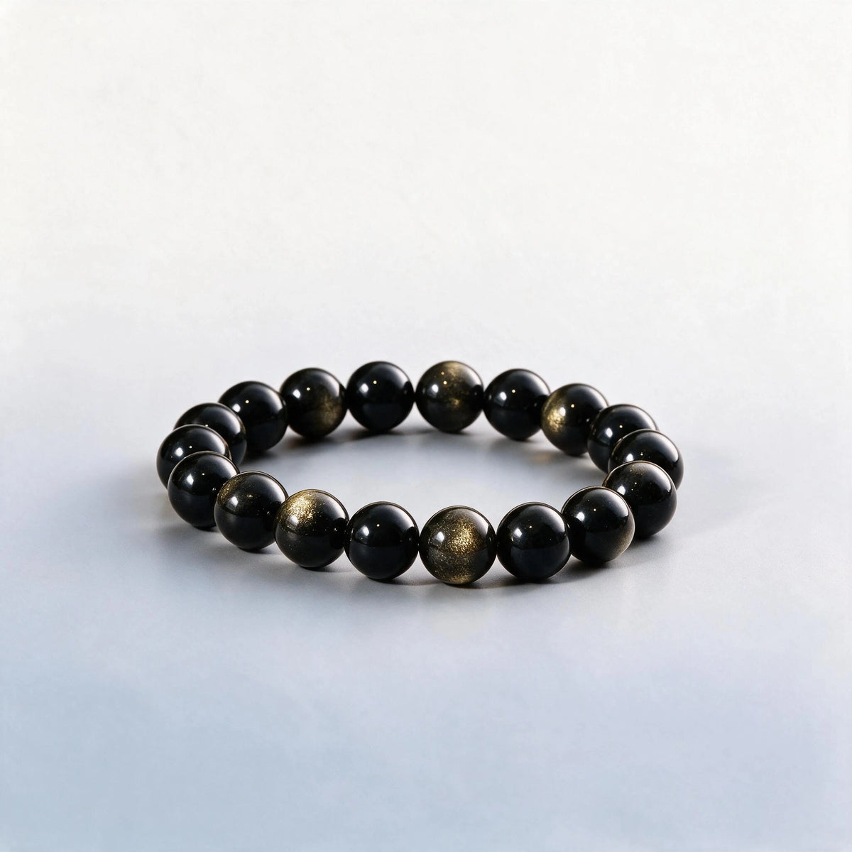 Handcrafted Root & Solar Plexus bracelet featuring black and gold sheen obsidian beads by Ember Quiet.
