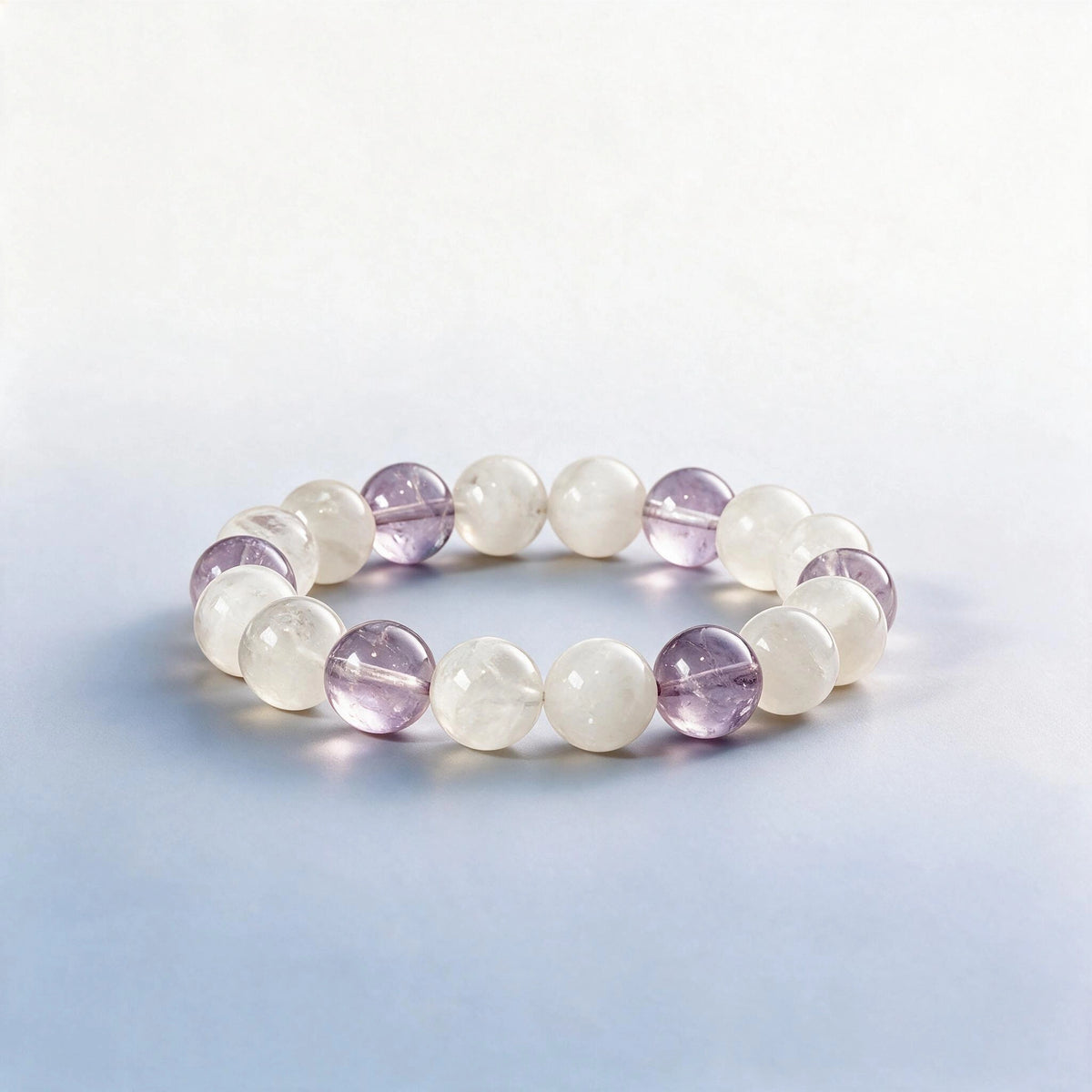 Handcrafted Crown Chakra bracelet featuring natural lavender amethyst and white phantom quartz beads by Ember Quiet.