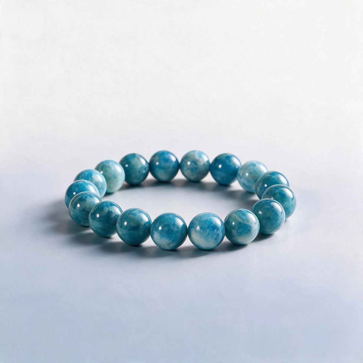 Handcrafted Third Eye & Throat Chakra bracelet featuring natural oceanic blue apatite beads by Ember Quiet.