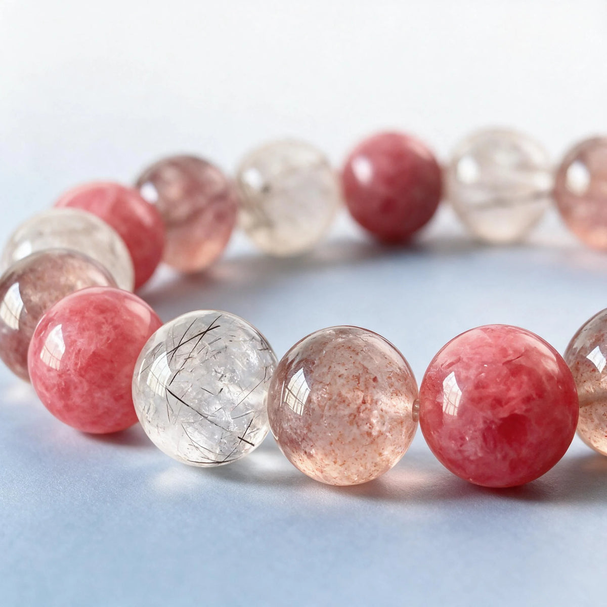 Macro close-up of authentic natural rhodonite, needle rutilated quartz, and strawberry quartz inclusions by Ember Quiet.