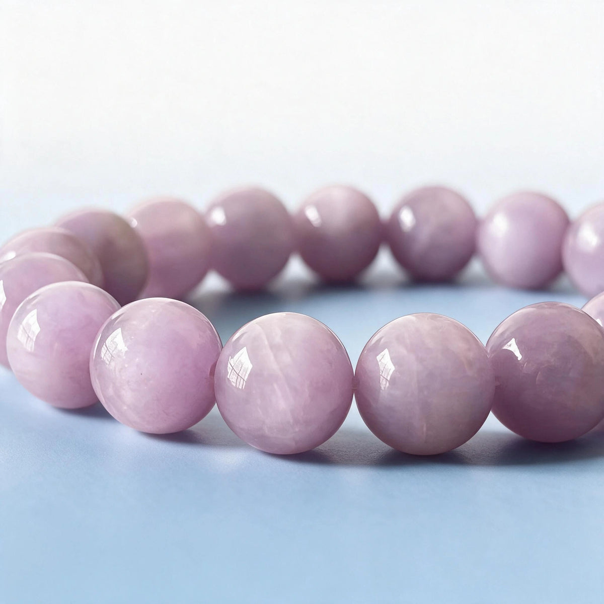Macro close-up of authentic natural lilac kunzite beads with delicate silky cleavage veils by Ember Quiet.