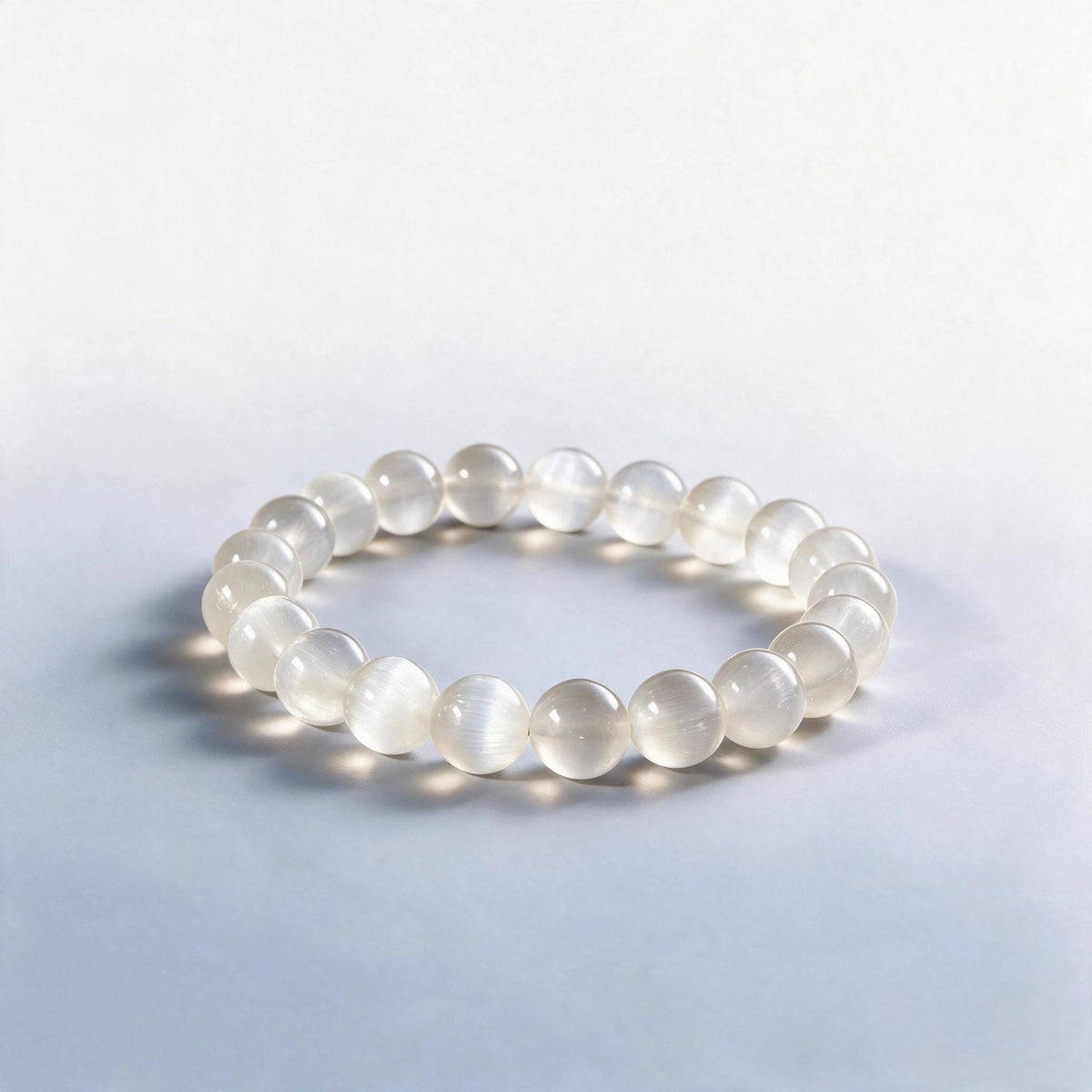 Handcrafted Crown Chakra bracelet featuring natural white satin spar selenite beads by Ember Quiet.
