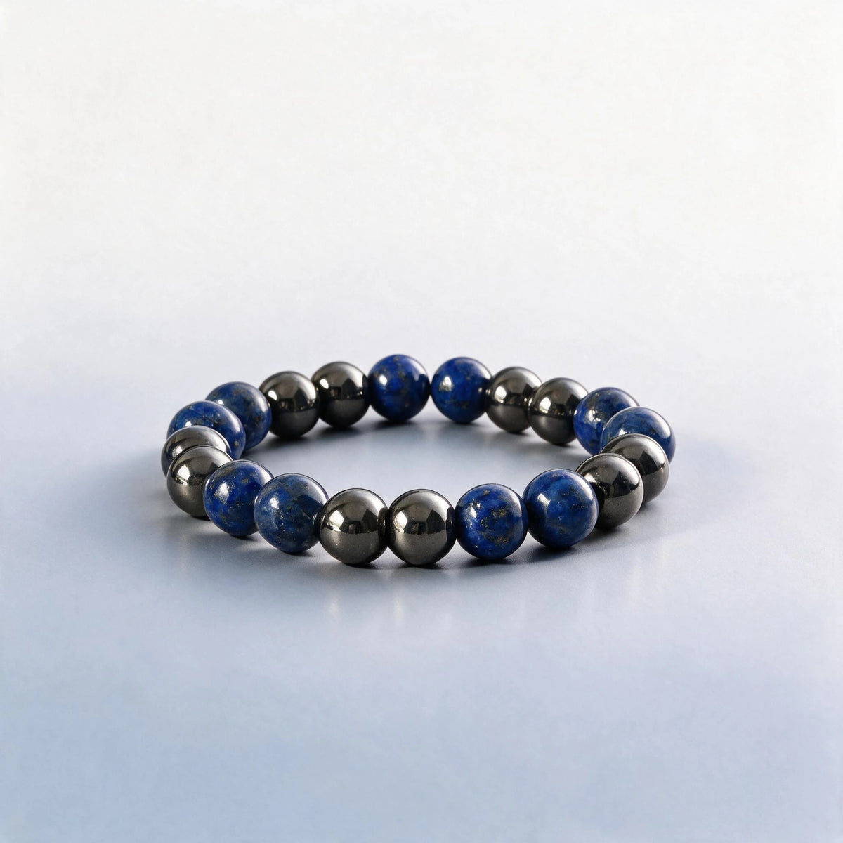 Handcrafted Throat & Root Chakra bracelet featuring natural lapis lazuli and metallic hematite beads by Ember Quiet.