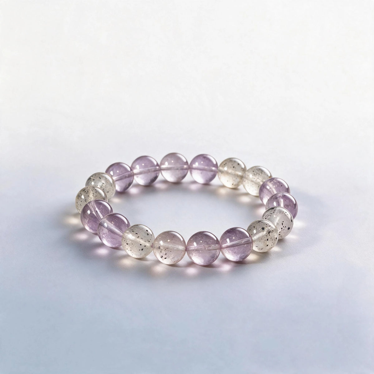 Handcrafted Crown & Third Eye Chakra bracelet featuring natural lavender amethyst and black strawberry quartz by Ember Quiet.