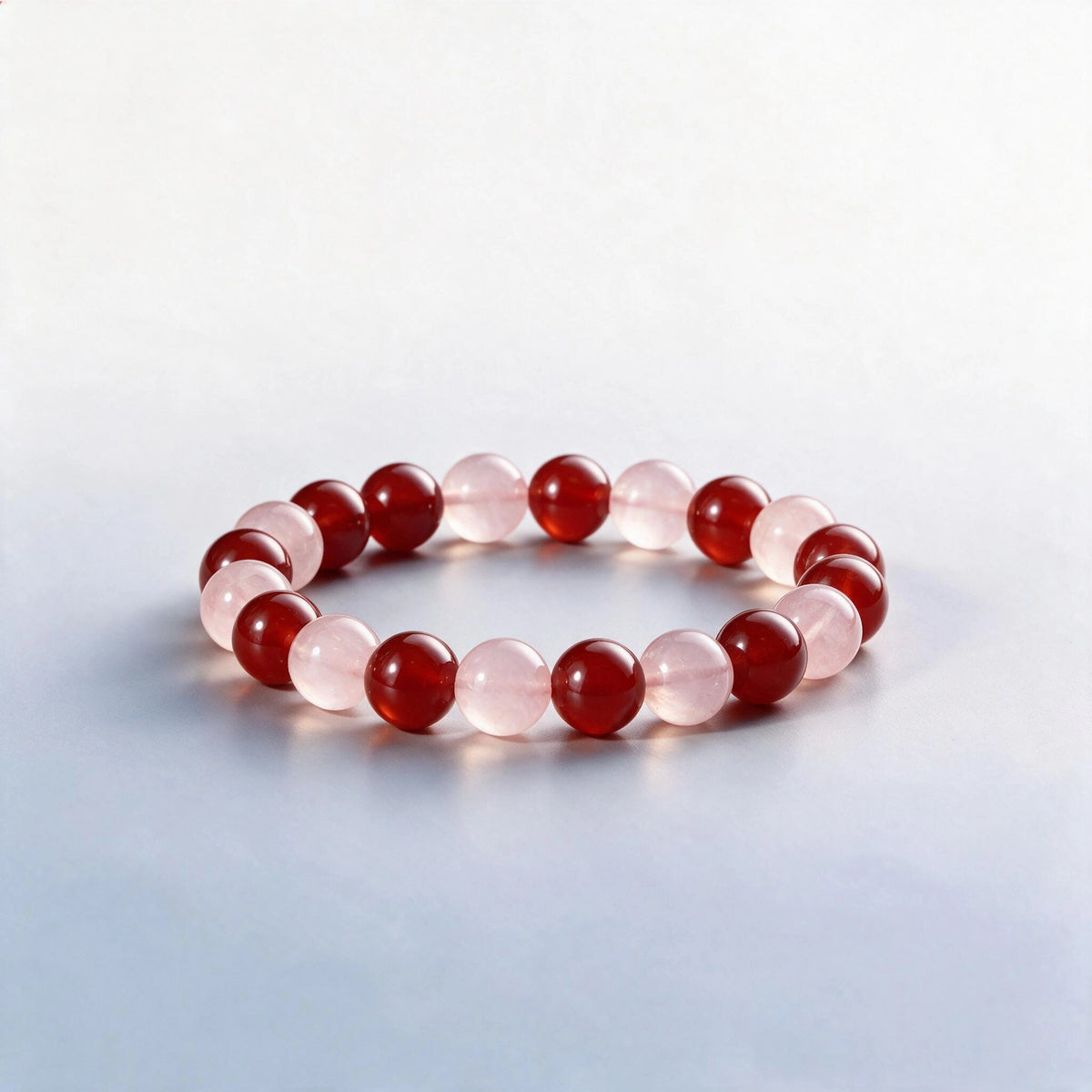 Handcrafted Root & Heart Chakra bracelet featuring natural red agate and rose quartz beads by Ember Quiet.