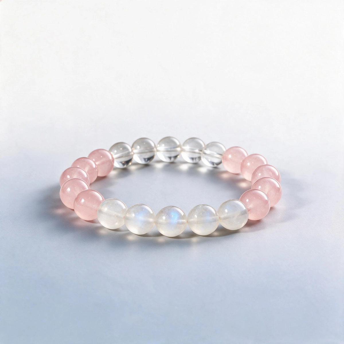 Handcrafted Heart & Crown Chakra bracelet featuring natural moonstone, rose quartz, and clear quartz by Ember Quiet.