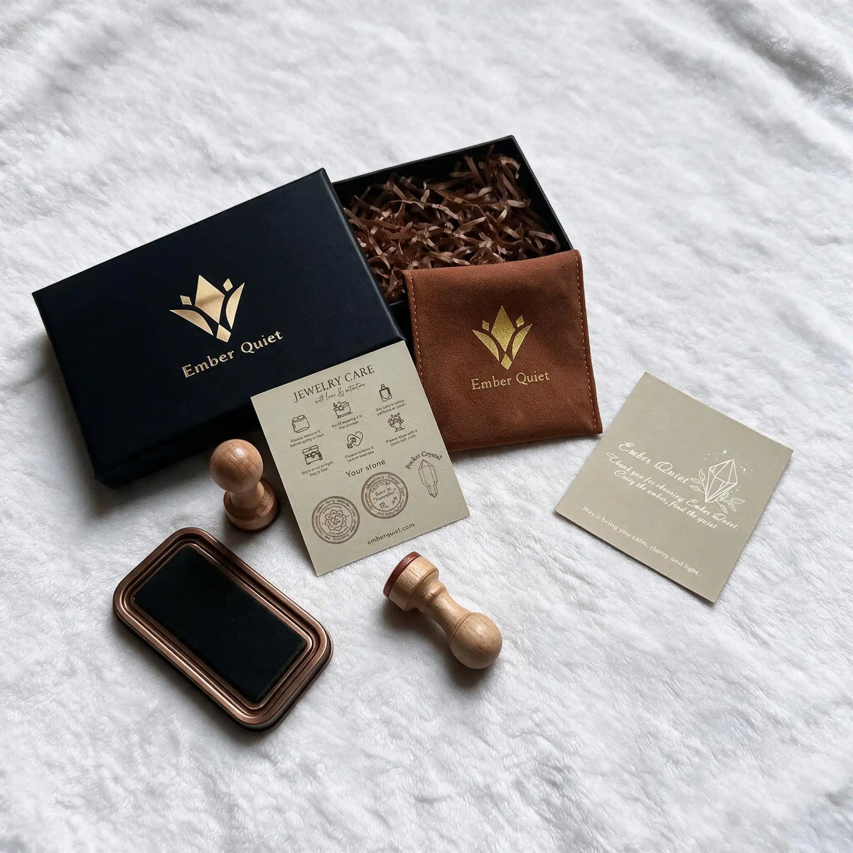 Ember Quiet crystal bracelet gift packaging — black keepsake box, branded velvet pouch, jewelry care card, and thank-you card.